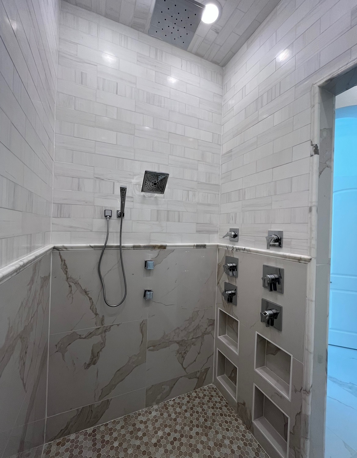 Custom marble tile shower with multi-head fixtures